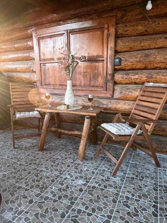 a room with a table and a chair and a vase with flowers at Artem Chalet in Ciocanu