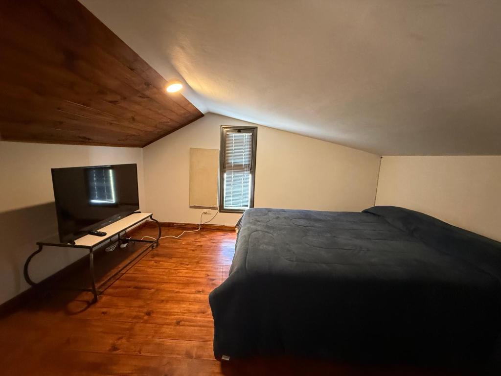 a bedroom with a bed and a flat screen tv at Cabañas boutique Huella Andina in Potrerillos