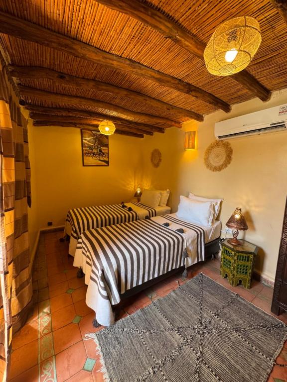 une chambre avec deux lits dans une pièce dans l'établissement Riad Andalla, à Marrakech