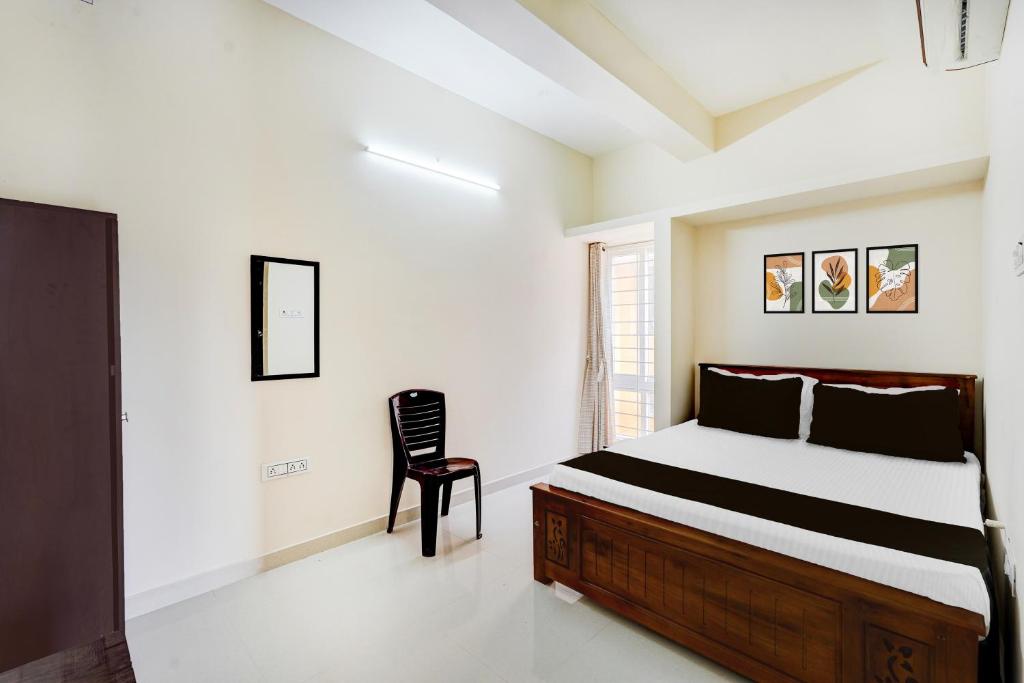 um quarto com uma cama e uma cadeira em Super Collection O Sholinganallur Chennai Formerly Nimalan Residenc em Chennai