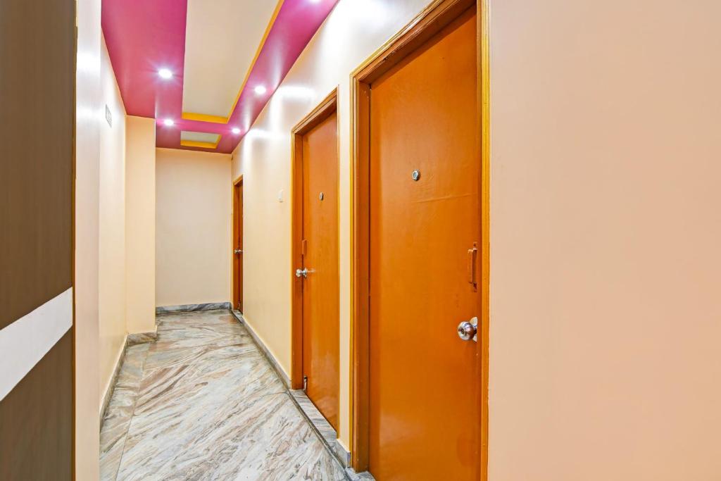 a hallway with a door and a purple ceiling at Super Hotel O Rishra Railway Station Formerly Green Guest House in Khardah
