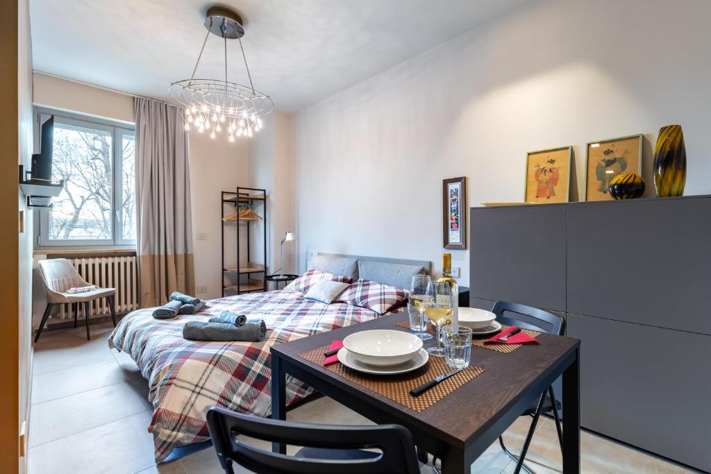 a living room with a bed and a table with chairs at Incantevole Appartamento in centro ad Alba in Alba