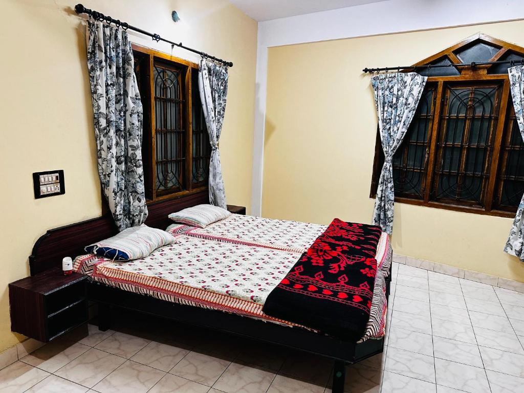 a bedroom with a bed and a window at Aksha Inn in Madikeri