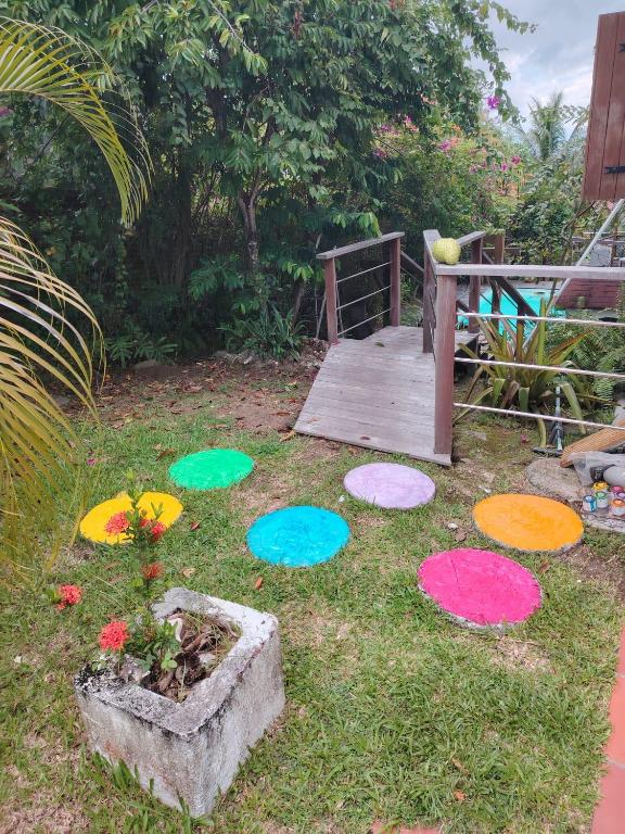 a garden with colorful rang mats on the grass at LE DIAMANT Charmante Villa pour la famille ou entre amis SPA et Piscine in Le Diamant