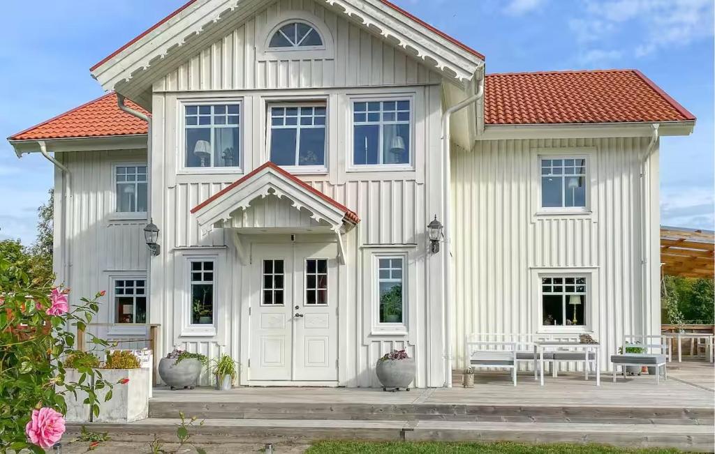 a white house with two benches in front of it at Lev ut din Gårdsdröm! in Svängsta
