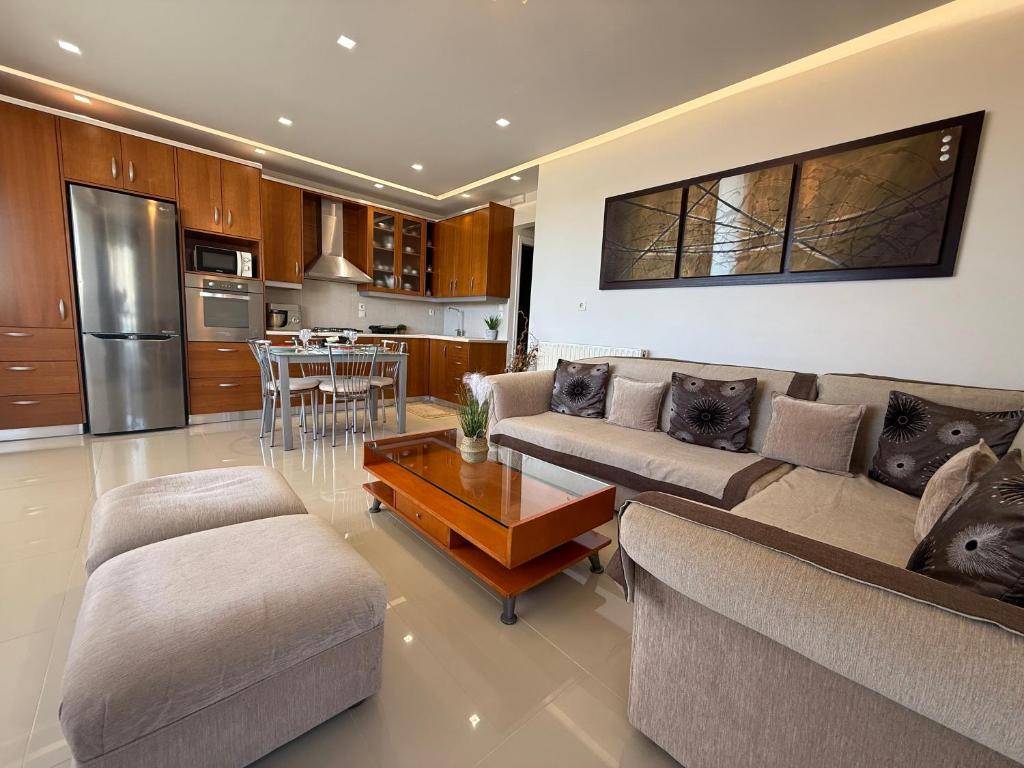 a living room with two couches and a kitchen at Anna's Seaside Apartment - In front of the beach in Kos Town