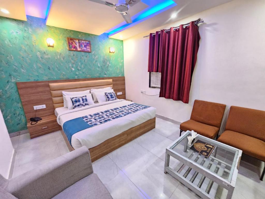 a hotel room with a bed and a couch and a chair at Hotel SAROS SUITES Near Delhi AIRPORT By GROSS GROUP in New Delhi