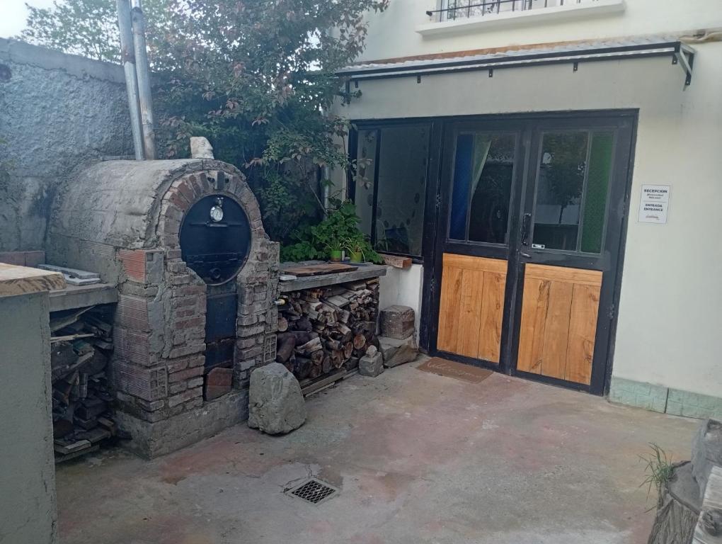a brick oven in front of a house with a door at Hostel Plataforma Home in El Bolsón