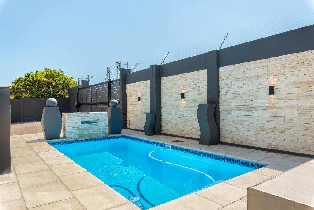 a swimming pool on a house with a brick wall at 51 Dolphin Drive in Cape Town