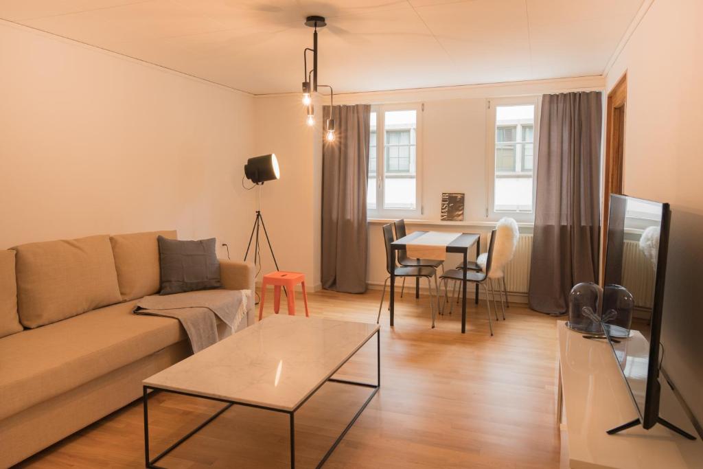 a living room with a couch and a table at Stylish Apartment in the Heart of Zug by Airhome in Zug