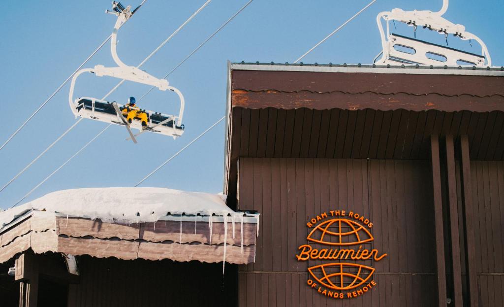 a person riding a ski lift over a building at Le Val Thorens, a Beaumier hotel in Val Thorens