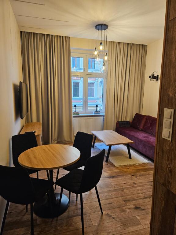 a living room with two tables and a couch at Apartament z antresolą Stare Miasto in Kłodzko