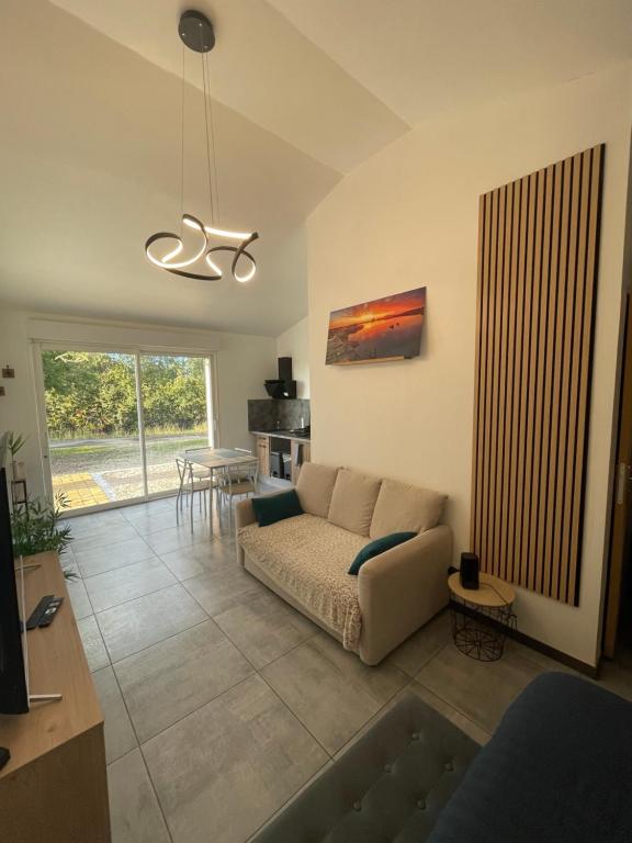 Saint-Georges-des-CôteauxにあるMaison avec grand espace en hauteurのソファとテーブルのあるリビングルーム