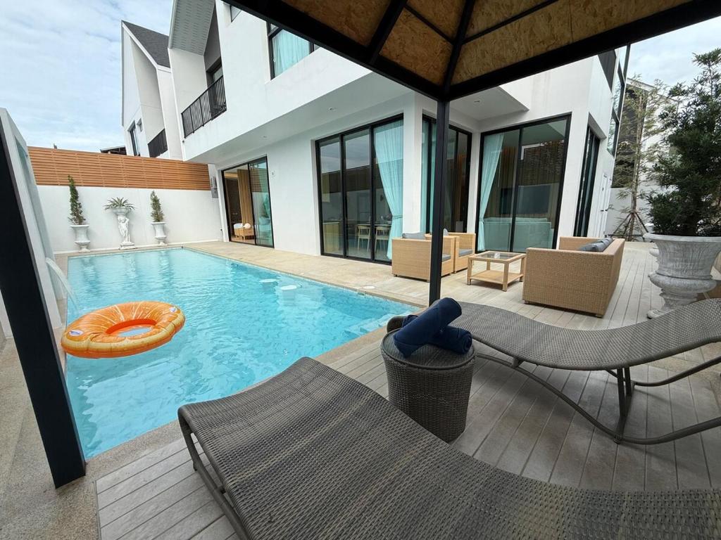 a swimming pool with an orange lifesaver in a house at Bangtao Brand New Luxury Modern Pool Villa Laguna Phuket in Thalang