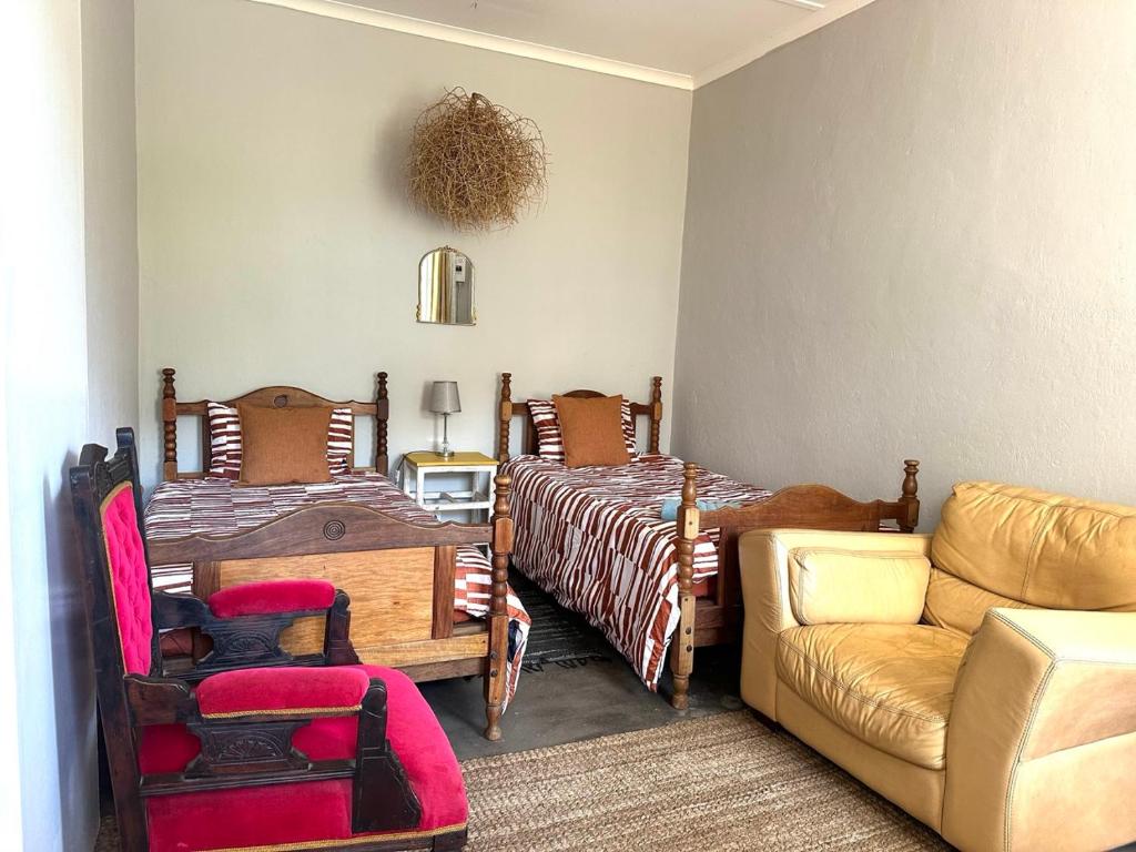 a bedroom with two twin beds and a couch at Rus n Bietjie Guest House in Loxton