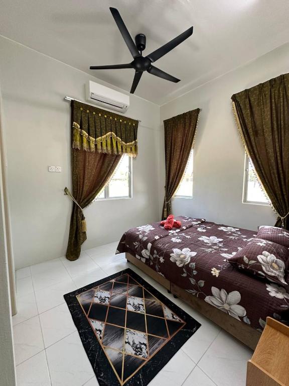 a bedroom with a bed and a ceiling fan at Zarul Homestay in Bachok