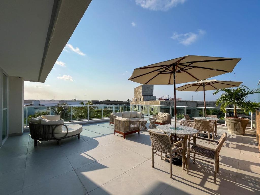 a patio with a table and chairs and an umbrella at Flat Nixxus Porto de Galinhas Ipojuca in Porto De Galinhas