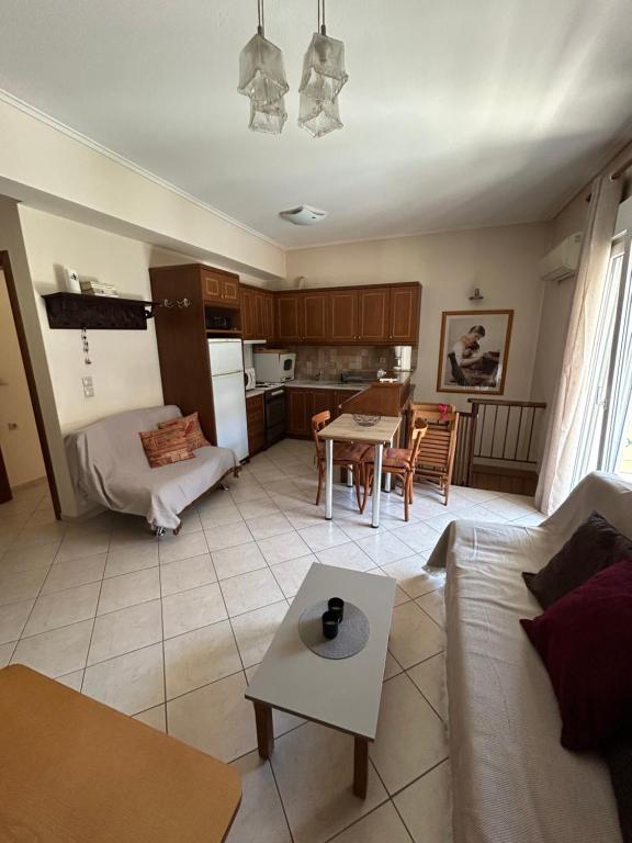 een woonkamer met een bank en een tafel bij Basis Apartment in Karpenisi