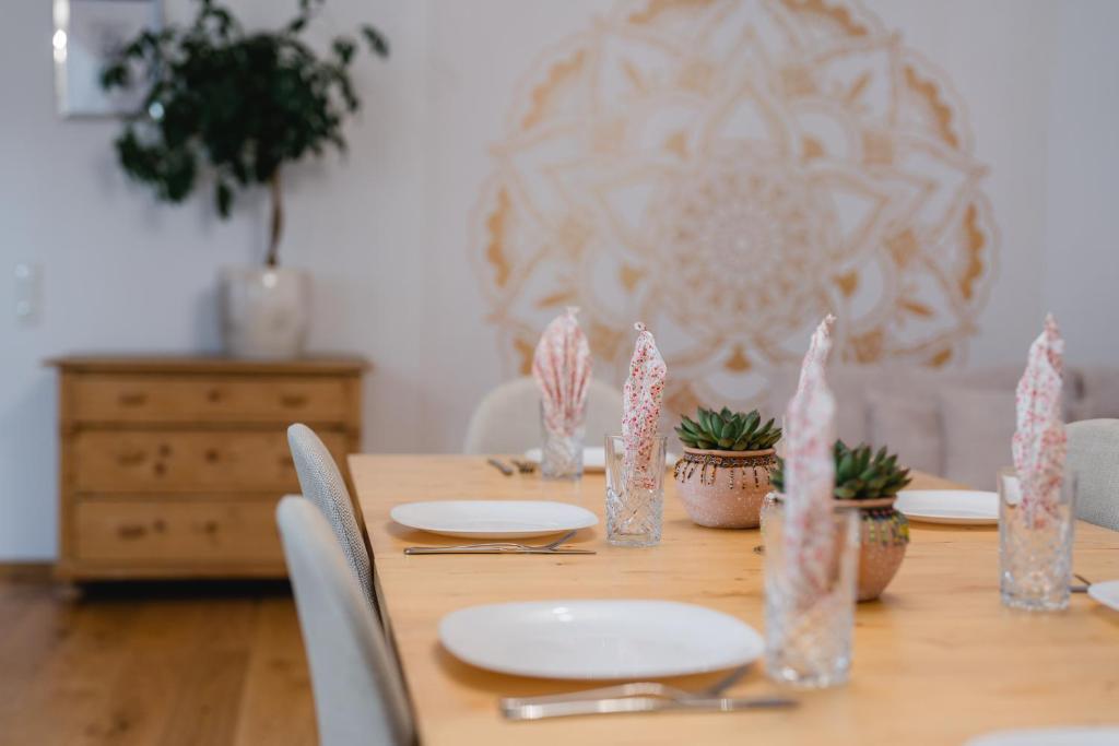 une table en bois avec des assiettes et des plantes dessus dans l'établissement Ferienwohnung Jelen - Kaffee - Tee - Lichthof - 135 qm, à Kolbermoor