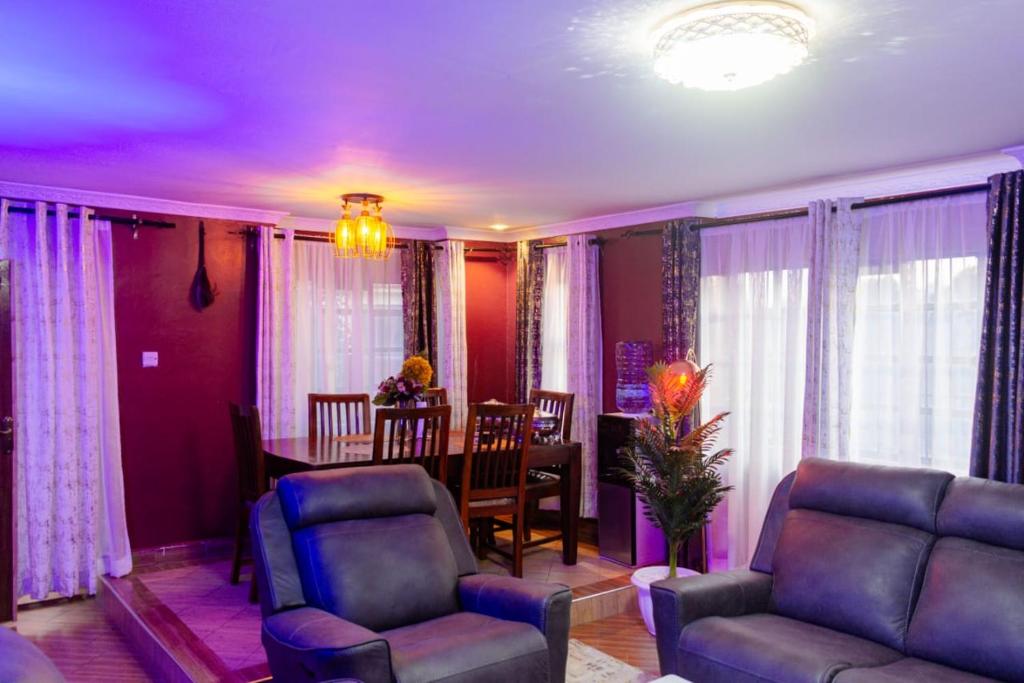 a living room with a couch and a dining room at Micasa Pent House MAIN in Limuru