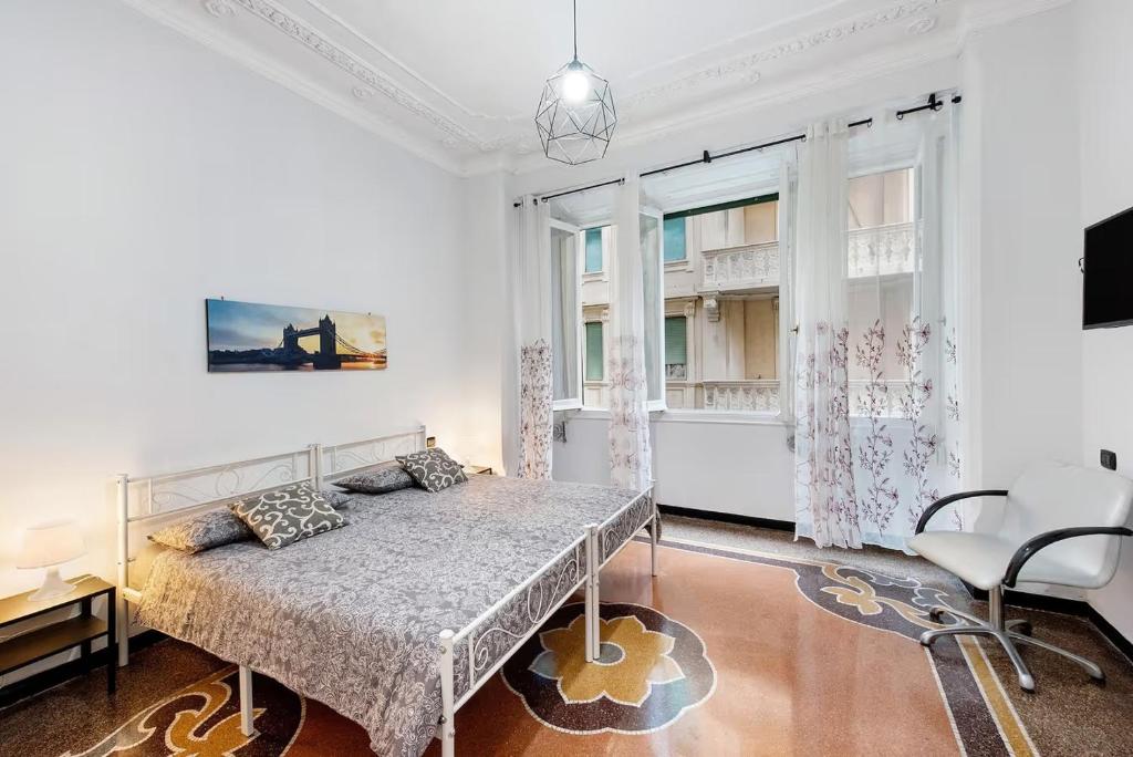 ジェノヴァにあるBenny appartamento 3 CAMERE DA LETTO ad uso ESCLUSIVO Genova Aeroportoのベッドと大きな窓のある白い寝室