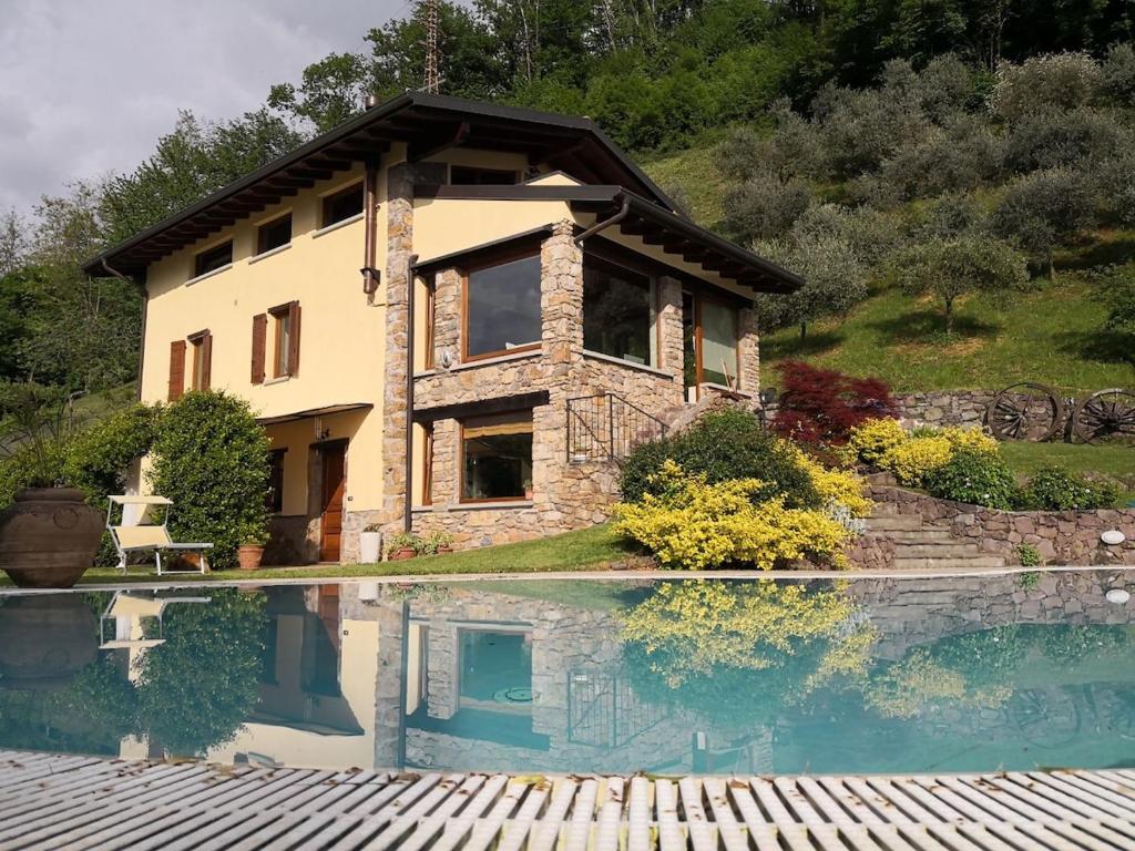 una casa con un reflejo en una piscina en Ronco Frati, piscina vista lago, en Pisogne