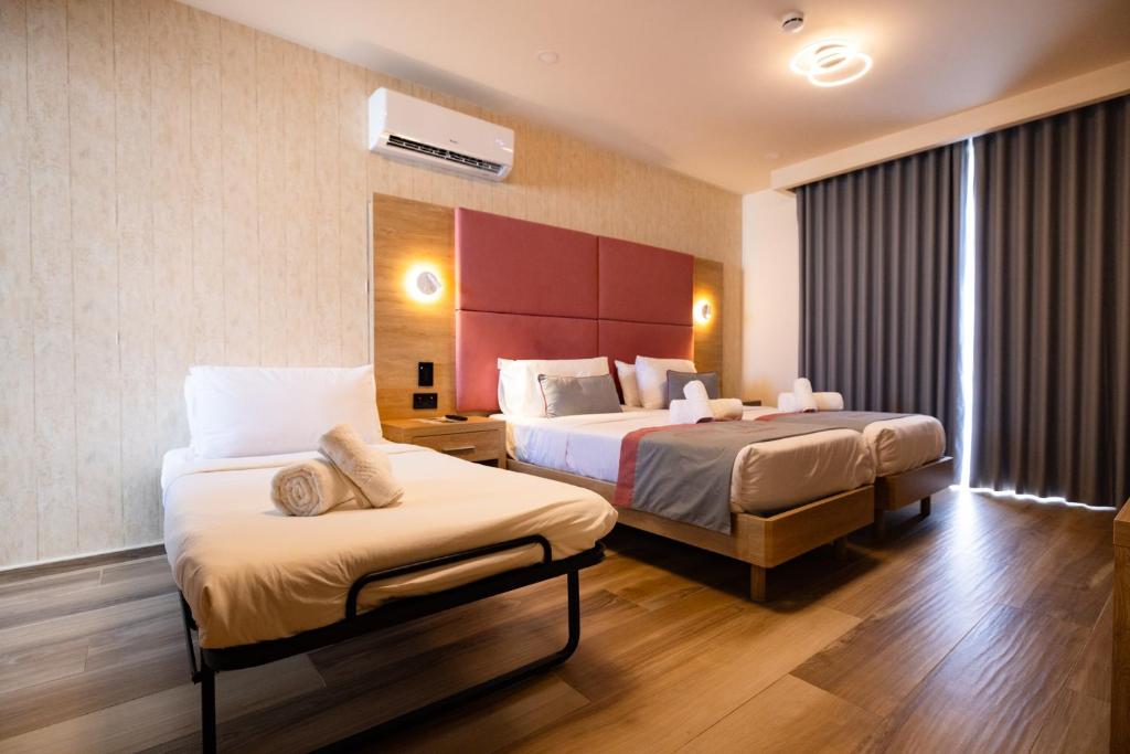 Is-SwieqiにあるC'est La Vie Boutik Swieqiのベッドが2つと窓があるホテルの部屋