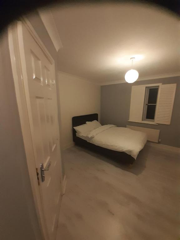 een slaapkamer met een bed en een witte deur bij Starfluence Properties - Spacious Ensuite in Gravesend