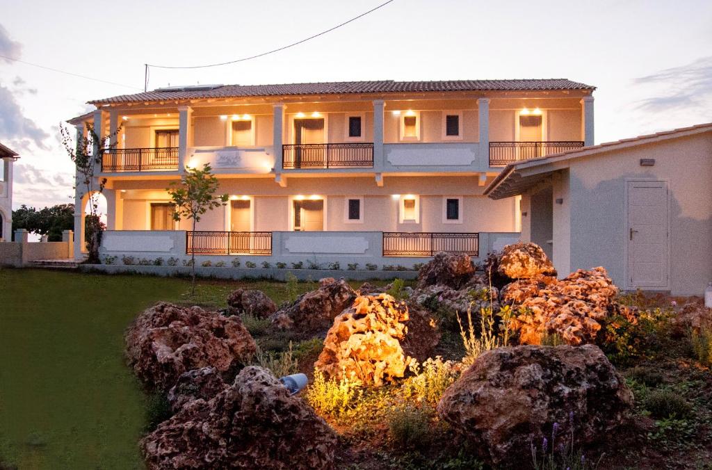 duży dom z kamieniami przed nim w obiekcie Hyacinthus-Cressida Seaside Apartments w Acharavi