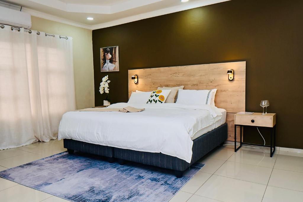 a bedroom with a large bed with a wooden headboard at Tsholofelo East Guesthouse in Gaborone