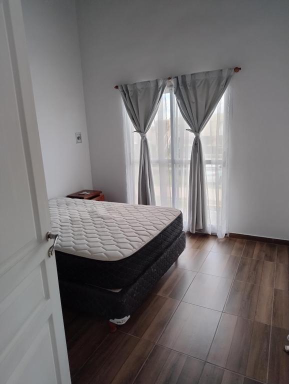 a bedroom with a bed and a window at Apart Atlántida I in Santa Clara del Mar