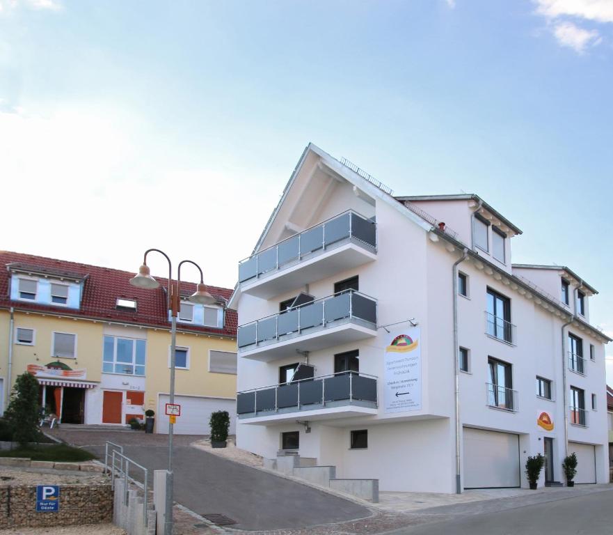 a white building with balconies next to a street at Apartments Am Grafenberg in Grafenberg