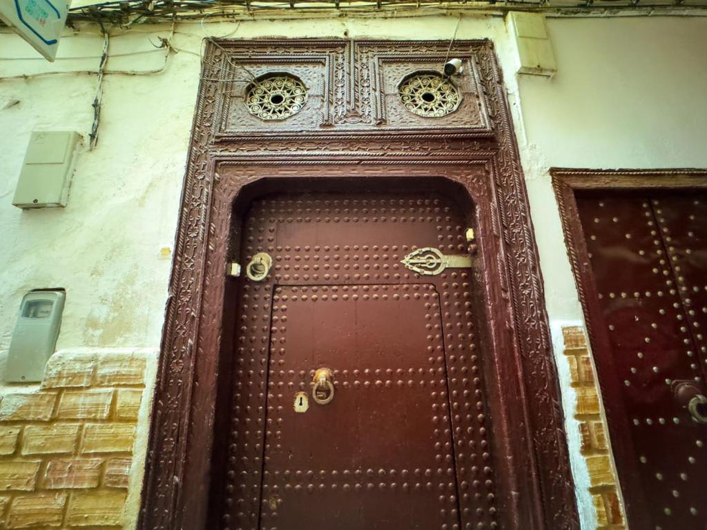 a brown door with a metal frame on a building at vintage in Fez