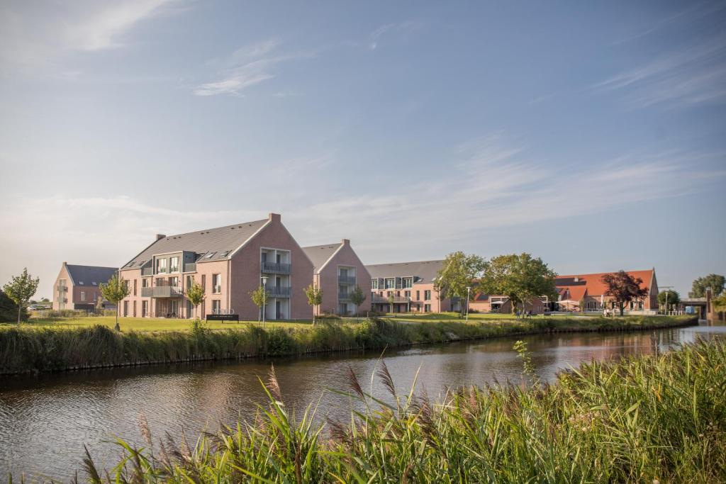 a row of houses next to a river at NOORD Carolinensiel in Carolinensiel