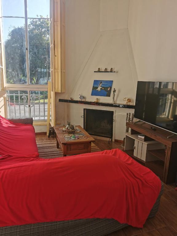 a living room with a red bed and a flat screen tv at La Abuelita in Rocha