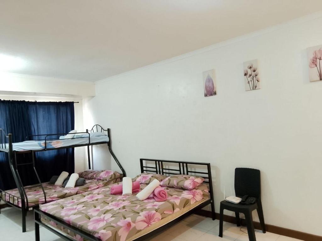 Un dormitorio con dos literas y una silla. en Albergo Hotel Unit near Wright Park, The Mansion, Minesview & Botanical Garden, en Baguio