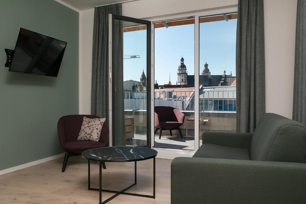a living room with a couch and a view of a city at Brera Leipzig in Leipzig