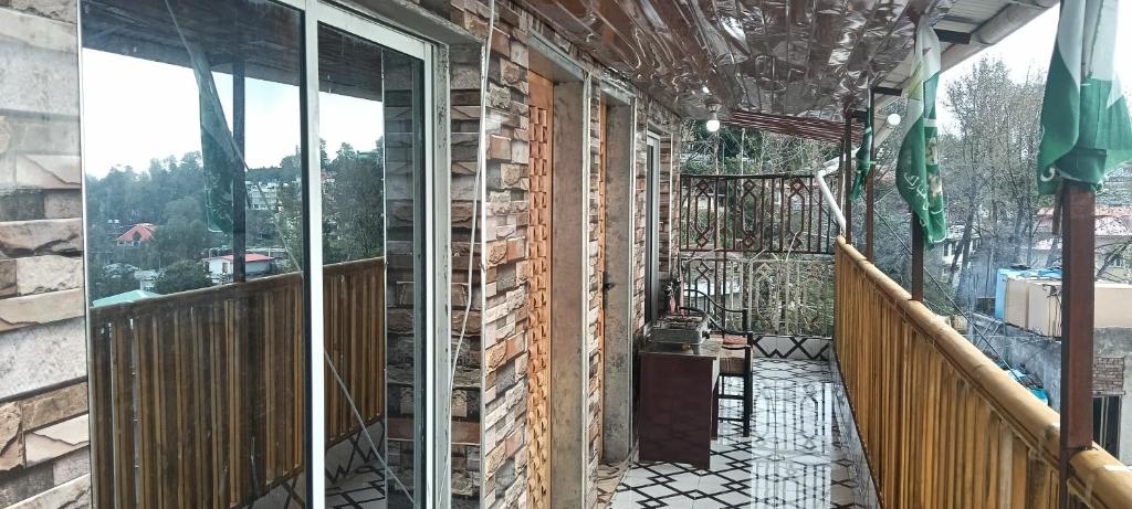 a house under construction with glass doors on a balcony at Al Jannat Nature view Rooms in Murree