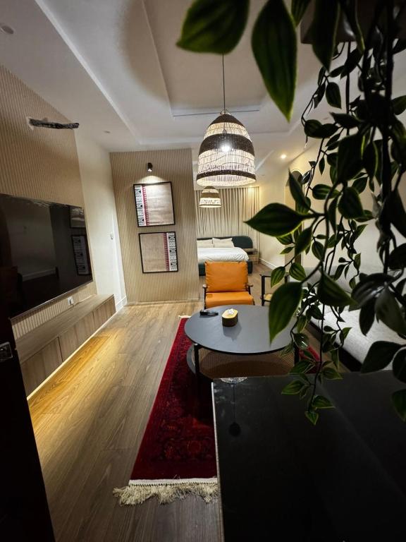 een woonkamer met een bank en een potplant bij Najdeh Suite, our goal is to make you comfortable in Jeddah
