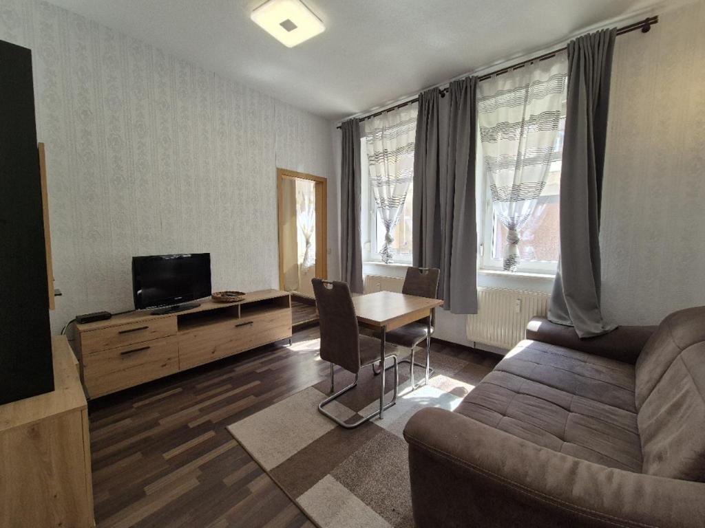 a living room with a couch and a table and a television at Mikra Homes24 in Meerane in Meerane