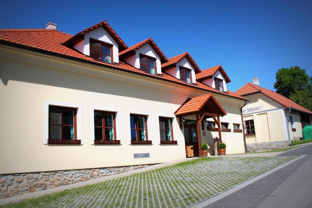 a white building with red roofs and a street at Penzion U Rudolfů in Vlasenice