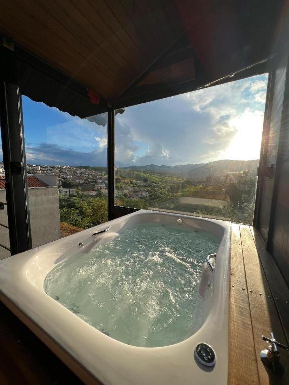 una bañera en una habitación con vistas en Deck's Chalés Serra da Canastra, en São Roque de Minas
