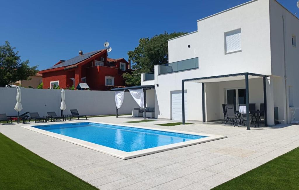 a swimming pool in front of a white house at Holiday home Iva by Villas Guide in Vrulje