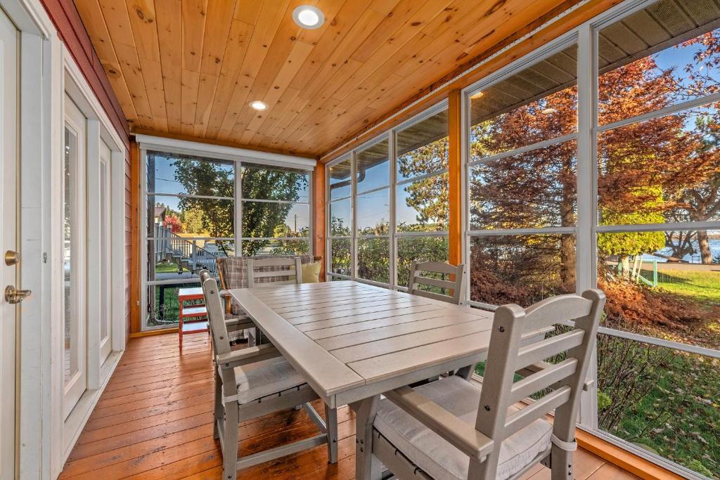 Arbor VitaeにあるRed Arbor Retreat in Arbor Vitae WIの木製テーブルと椅子付きのポーチ