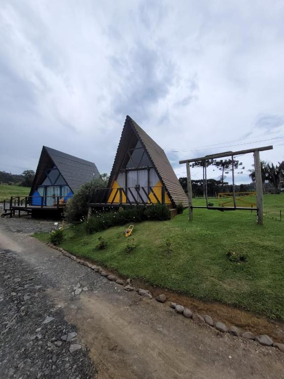 a couple of houses on the side of a road at Chalé Encanto Do Lago in Urubici