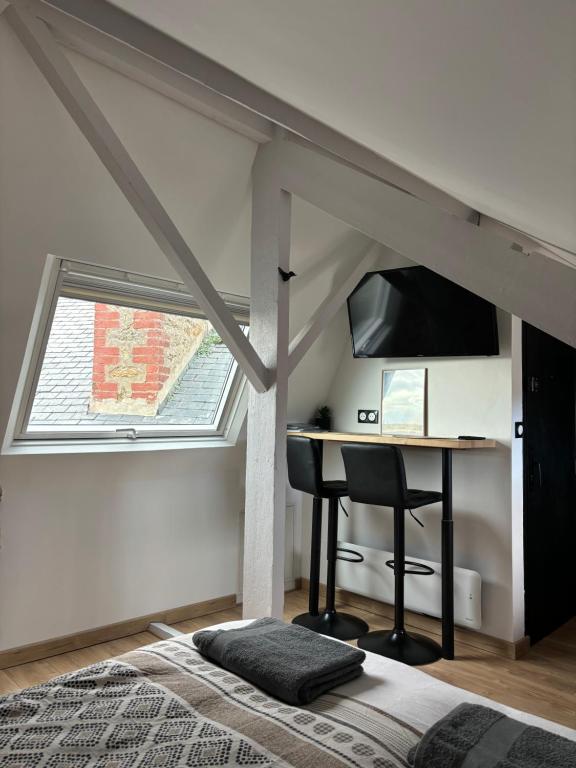 a bedroom with a desk and a window and a bed at Petit cocon avec vue sur mer in Dinard