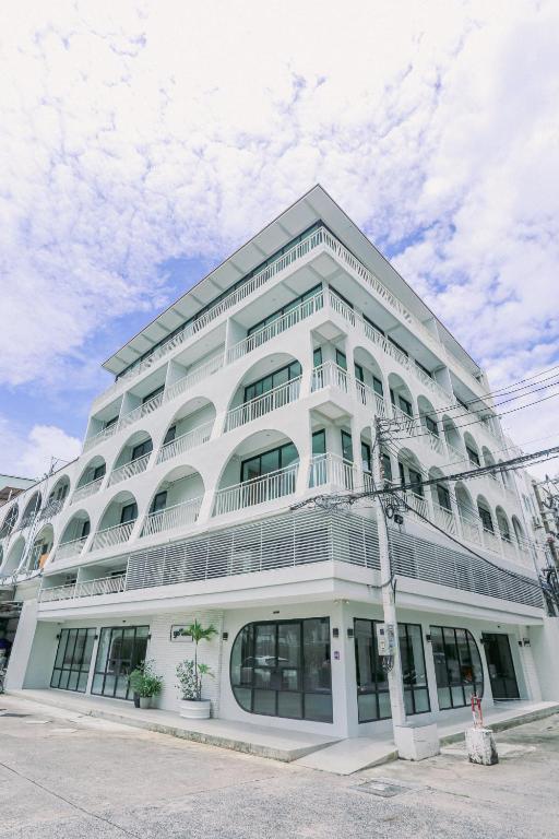 a large white building with windows on a street at Go2bed Pattaya Hotel in Pattaya