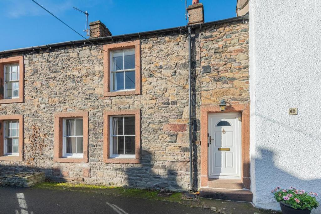 a stone house with a white door and windows at 2 Bed in Pooley Bridge oc-r33740 in Pooley Bridge