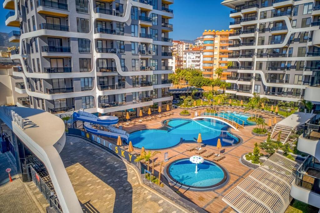 an apartment with a swimming pool and some buildings at 'Ultra Luxury Holiday Apt in the Heart of the City in Alanya