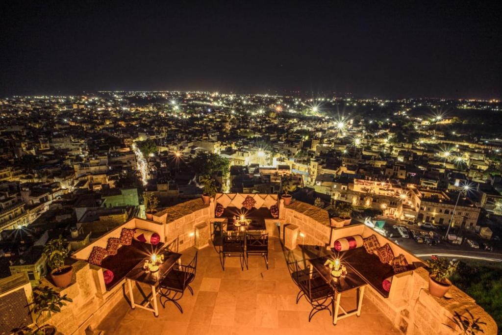 a view of a city at night with tables and chairs at Hotel Rajmandir in Jaisalmer